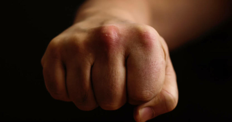 Fist on a black background, a punch in the face
