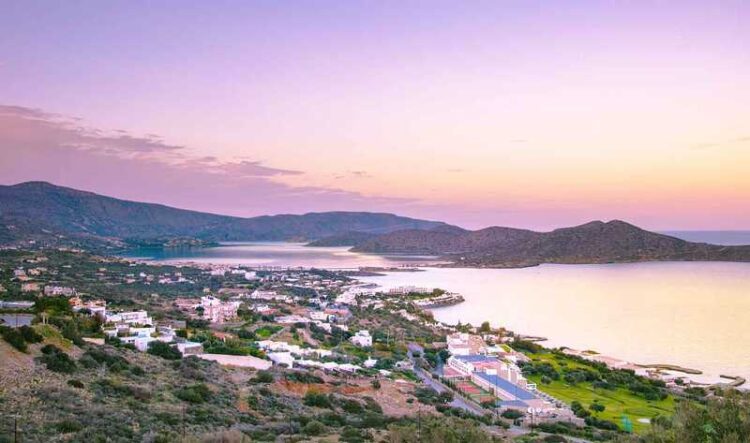 Panoramic view of the gulf of Elounda with the famous village of Elounda and the island of Spinalonga at sunset with nice clouds and calm sea,