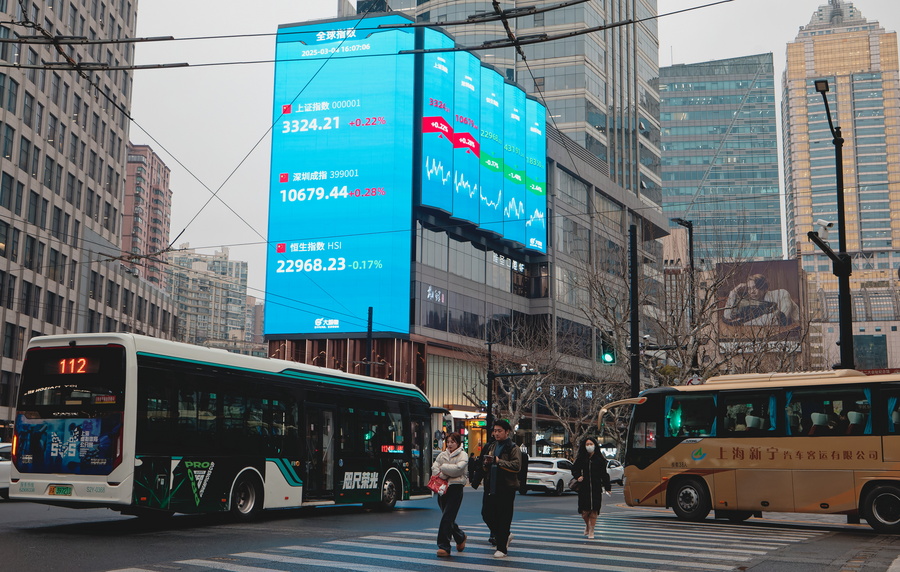 epaselect epa11939142 People cross the street below a display showing the latest economy and stock exchange data, in Shanghai, China, 04 March 2025. US stock markets declined after President Donald Trump announced an additional 10 percent tariff on Chinese imports, on top of the existing 25 percent tariffs on goods imported from Canada and Mexico. EPA/ALEX PLAVEVSKI