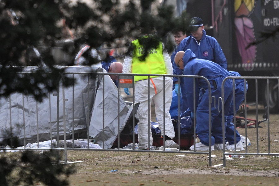 epa12592714 Forensic officers examine a victim's body at the scene of a shooting at Bondi Beach in Sydney, Australia, 15 December 2025. At least 16 people were killed in a shooting incident on 14 December at the Jewish community's Hanukkah festival celebrations at Bondi Beach in Sydney. EPA/DEAN LEWINS AUSTRALIA AND NEW ZEALAND OUT