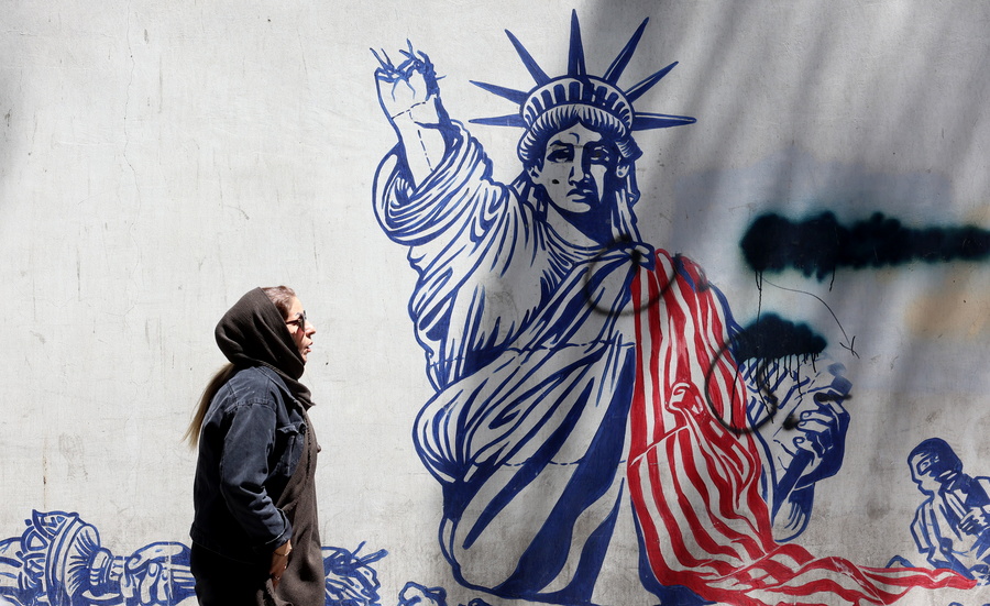 epa12994321 An Iranian woman walks next to an anti-US mural near to the former US embassy in Tehran, Iran, 26 May 2026. US President Donald Trump announced that a potential peace agreement to end the conflict and reopen the Strait of Hormuz has been largely negotiated through Pakistani mediators. However, the US has launched new strikes in southern Iran. EPA/ABEDIN TAHERKENAREH
