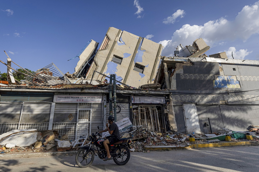 epa13112090 A person looks at buildings destroyed by earthquakes in Catia La Mar, Venezuela, 14 July 2026. The death toll from the twin earthquakes that struck northern Venezuela nearly three weeks ago rose to 4,734 on 14 July, after 173 new deaths were reported, according to National Assembly President Jorge Rodriguez. EPA/MIGUEL GUTIERREZ