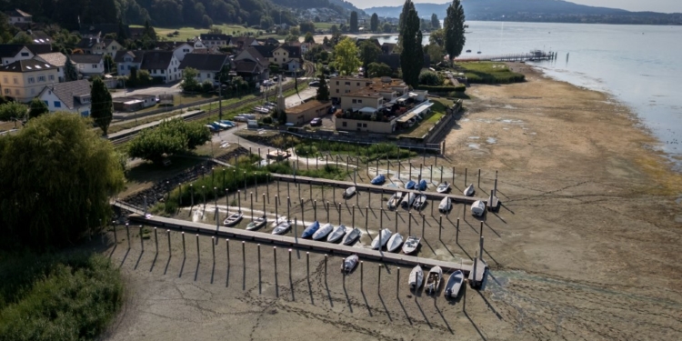 This aerial photograph shows a floating jetty and boats stranded on the dried-up shores of the Untersee, also known as Lower Lake Constance, during a heatwave in Mannenbach, northern Switzerland on August 15, 2026. (Photo by Fabrice COFFRINI / AFP)